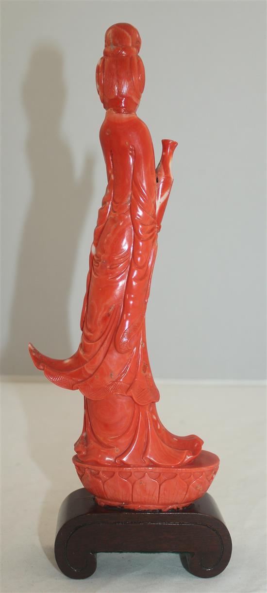 A large Chinese coral figure of Guanyin, 27.7cm incl. wood stand